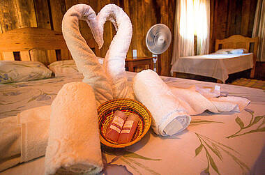 Herz aus Handtuchschwänen auf einem Bett in der Tupana Lodge