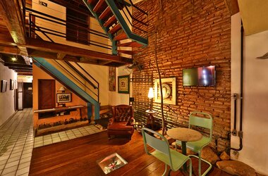 Innenbereich mit Sichtmauerwerk, Ledersessel und moderner Treppe in der Pousada do Amparo, Brasilien