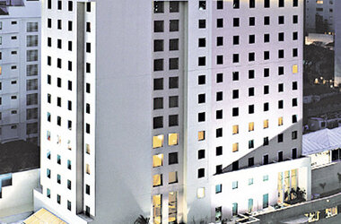 Außenansicht des weißen Hochhausgebäudes des Hotels Pestana Sao Paulo bei Dämmerung in Brasilien.