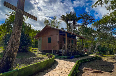 Gepflasterter Weg führt zu einem freistehenden Holzbungalow im Amazon Village, Brasilien.