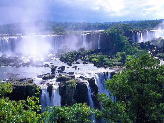 Die Foz do Iguaçu-Wasserfälle, gesehen zwischen zwei Plateaus, mit majestätischen Wasserfällen, die sowohl oben als auch unten in die Schlucht stürzen.