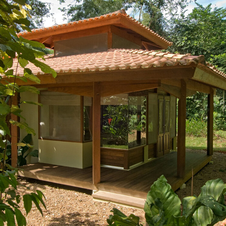 Freistehender Holzbungalow mit Ziegeldach inmitten dichter Vegetation in Alta Floresta.