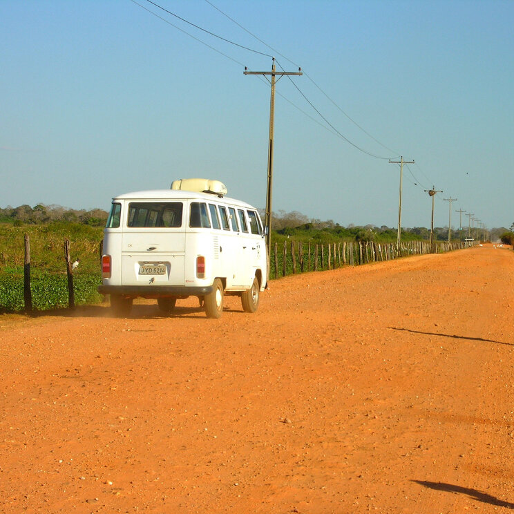 Weißer Van auf einer staubigen Straße im Pantanal, unterwegs vom Hotel UeSo Pantanal, Brasilien.