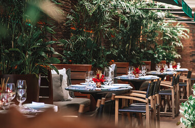 Restaurant Gero im Hotel Fasano mit eingedeckten Tischen und hohen Grünpflanzen in Rio de Janeiro.