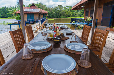 Gedeckter Holztisch auf einer schwimmenden Restaurant-Terrasse der Uakari Lodge im Amazonas, Brasilien.