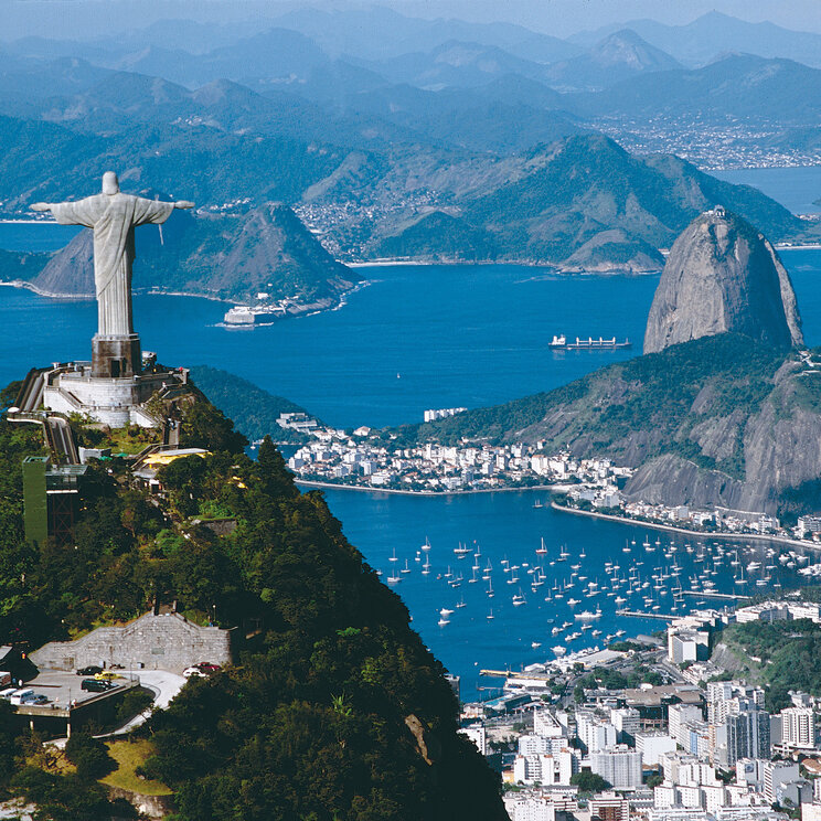Blick über Rio de Janeiro mit der ikonischen Christusstatue auf dem Corcovado und dem Zuckerhut im Hintergrund.