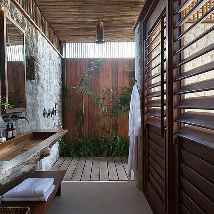 Badezimmer der Standard Suite im Hotel Villa Mandi in Jericoacoara, Brasilien, mit natürlichem Design und Blick auf den privaten Außenbereich.