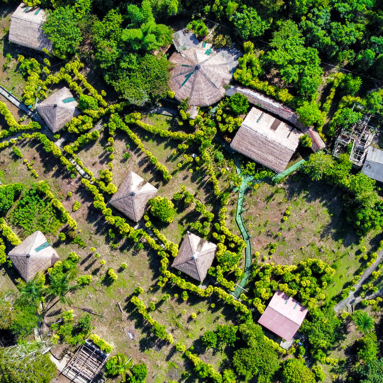Luftaufnahme der Bungalow-Anlage Amazon Village mit Strohdaechern im brasilianischen Regenwald.
