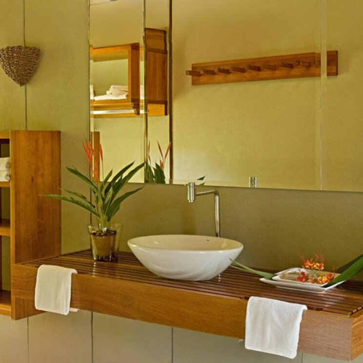 Modernes Badezimmer mit Aufsatzwaschbecken auf einem Holzunterbau und großem Spiegel.