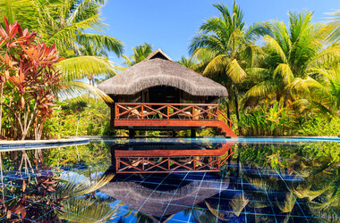 Tropischer Bungalow auf Stelzen über einem Pool im Garten des Nannai Resort, Porto de Galinhas.