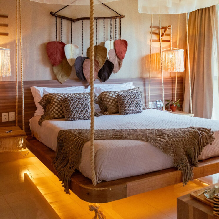 Hotelzimmer im Vivaz Cataratas, Foz do Iguaçu, mit Schwebebett, Nachttischen an Seilen und Makramee-Deko.