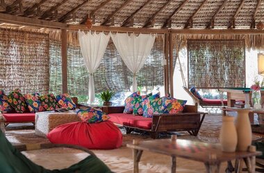 Loungebereich mit Strohdach und bunten Kissen im Hotel Vila Kalango in Jericoacoara im Bundesstaat Ceará in Brasilien.