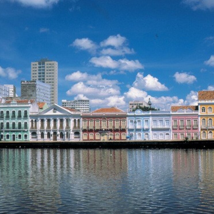 Bunte Kolonialgebäude spiegeln sich im Wasser am Ufer von Recife, Brasilien.