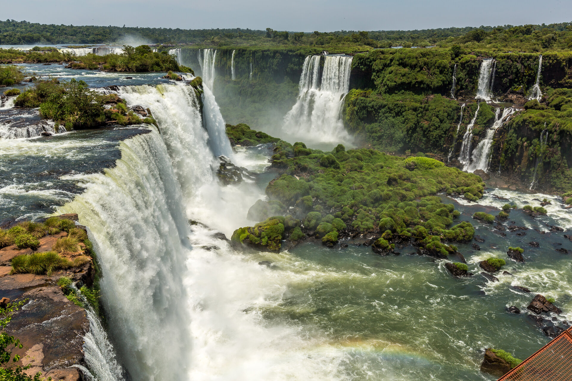 Panorama der Iguazú-Wasserfälle mit herabstürzenden Wassermassen und grüner Vegetation in Foz do Iguaçu, Brasilien.