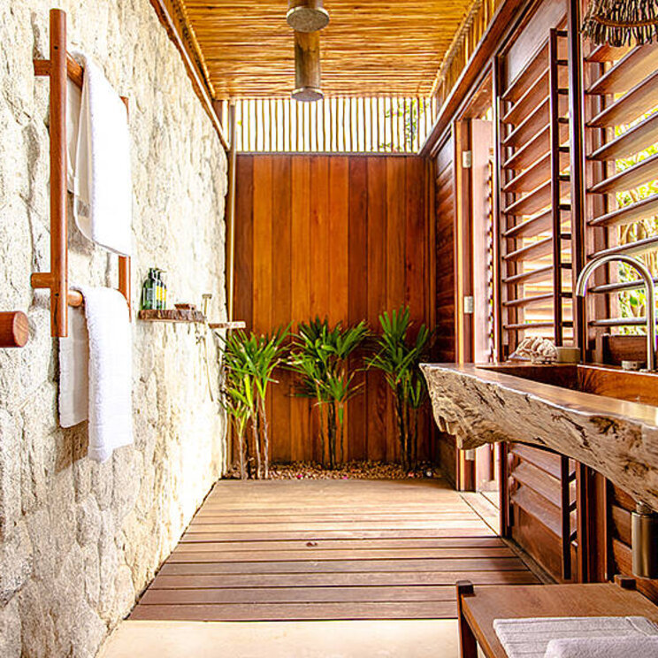Badezimmer der Deluxe Suite im Hotel Villa Mandi in Jericoacoara, Brasilien, mit natürlichem Design und Blick auf den privaten Außenbereich.
