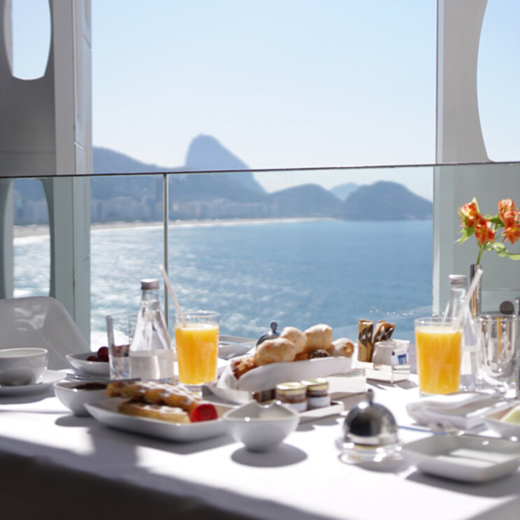 Gedeckter Frühstückstisch auf einem Balkon im Emiliano Rio mit Blick auf den Ozean und den Zuckerhut in Rio de Janeiro.
