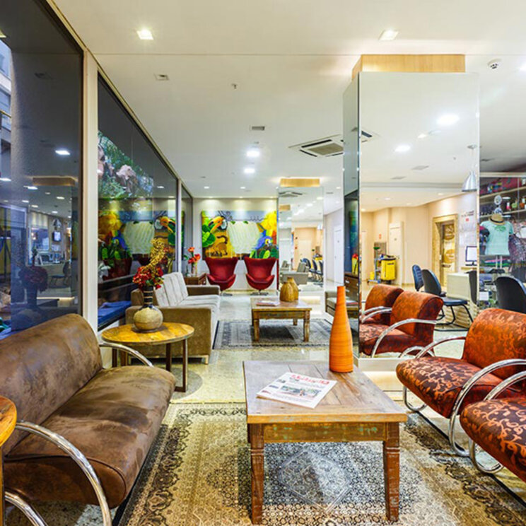  Farbenfrohe Lobby im Hotel Taroba mit gemütlichen Sitzgruppen, Holzmöbeln und großen Spiegelelementen in Brasilien.