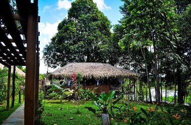 Hölzerner, palmengedeckter Pavillon der Turtle Lodge mit Hängematten