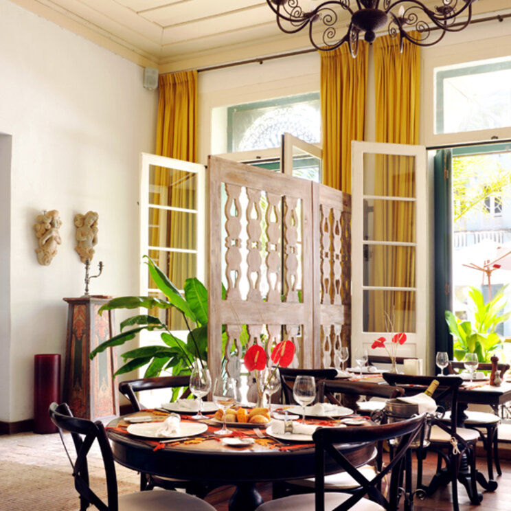 Restaurant im Hotel Villa Bahia mit dunklen Holzmoebeln, Kronleuchter und Blick auf den historischen Stadtteil Pelourinho.