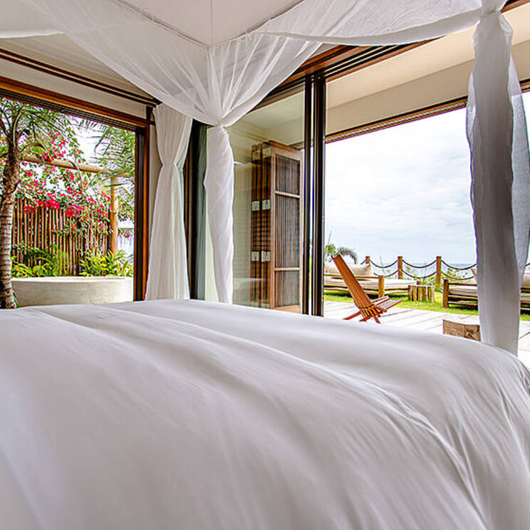 Zimmer in der Master Suite des Hotel Villa Mandi in Jericoacoara, Brasilien, mit direktem Zugang zur Terrasse und Blick auf den Garten.