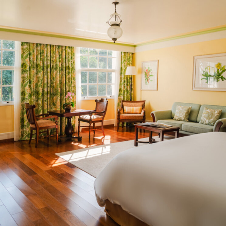 Noble Suite im Hotel das Cataratas mit gelben Wänden, Sitzecke und Vorhängen mit Blattmuster in Foz do Iguacu, Brasilien.