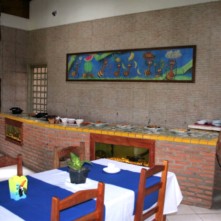 Rustikaler Speisesaal mit dekorativer Wandkunst im Hotel UeSo Pantanal, Brasilien.