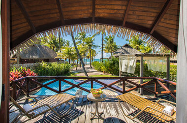 Terrasse mit Sonnenliegen und Blick über den Pool auf den Strand von Porto de Galinhas, Brasilien.