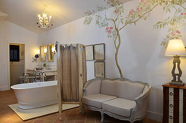 Badezimmer mit Wanne und Sofa im Master room des Hotels Vila da Santa