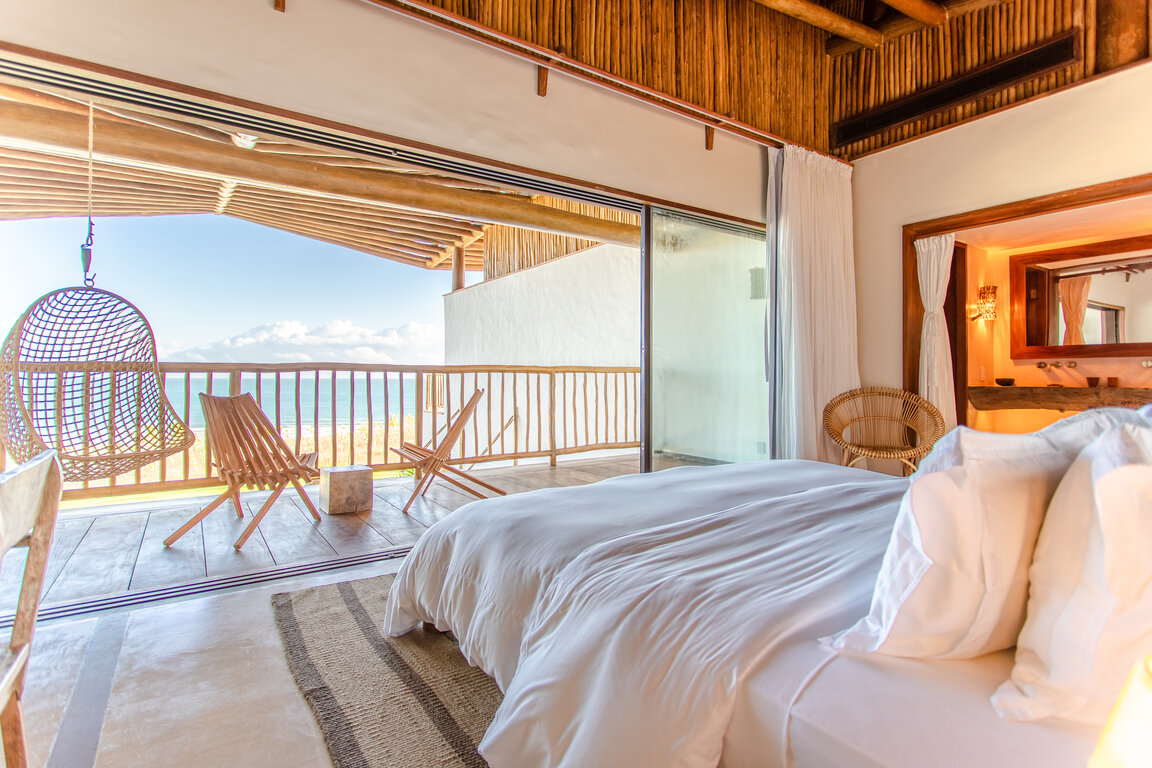 Master Suite im Hotel Villa Mandi in Jericoacoara, Brasilien, mit modernem Design und Zugang zum Badezimmer.