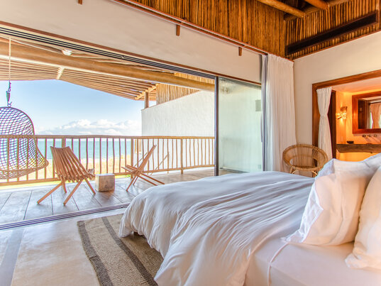 Master Suite im Hotel Villa Mandi in Jericoacoara, Brasilien, mit modernem Design und Zugang zum Badezimmer.