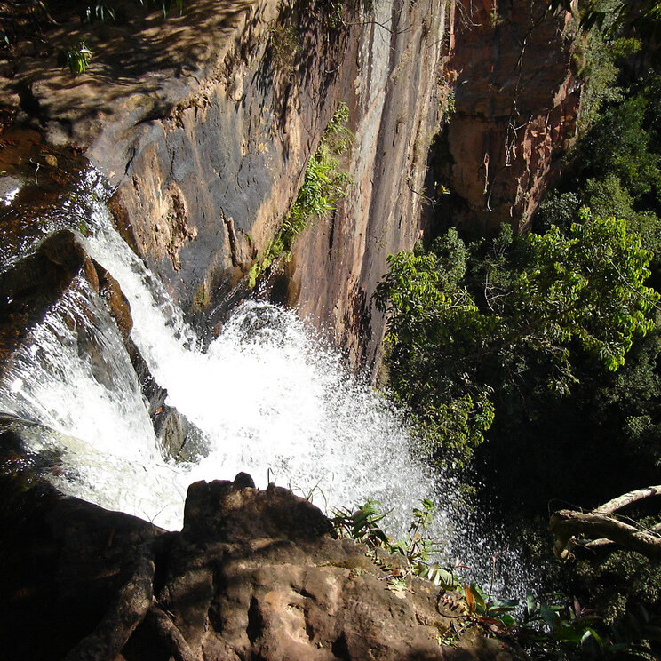 Wasserfall, der über Felsen inmitten der Vegetation in der Chapada dos Guimarães, Brasilien, herabstürzt.