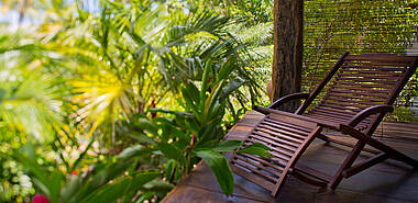 Liegestuhl auf einer Veranda mit Blick auf den tropischen Garten des Casa dos Arandis