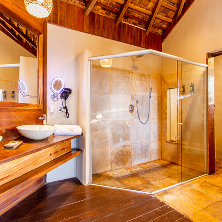 Badezimmer im Bangalo Luxo mit Doppelwaschbecken und Glasdusche unter einem Holzdach im Hurricane Jeri.