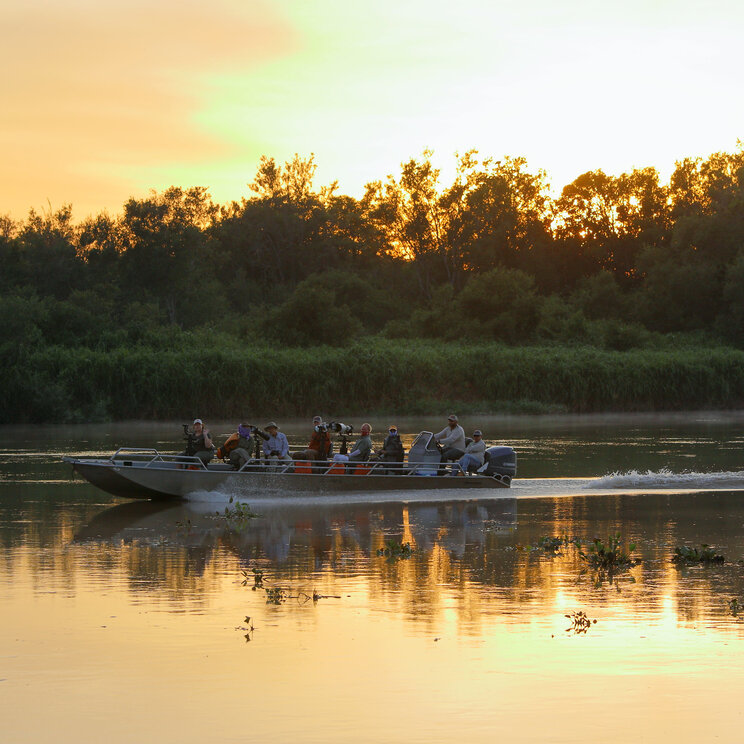 Bootsausflug mit Mutum Expeditions im Pantanal bei Sonnenuntergang mit ruhigem Fluss, Spiegelung und dichter Dschungel-Vegetation im Hintergrund