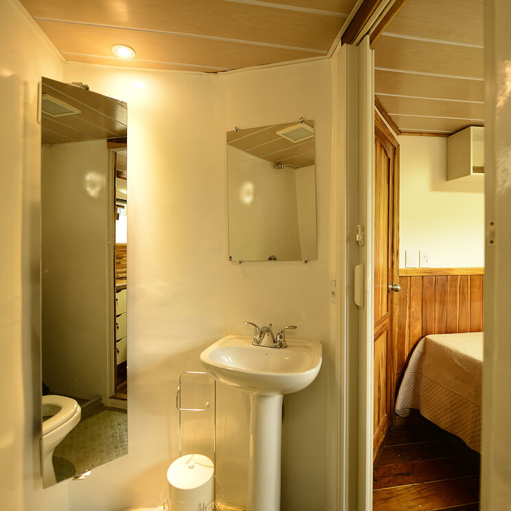 Badezimmer in einer Kabine des Mutum-Expeditionsboots im Pantanal, Brasilien, mit Dusche, Waschbecken und Toilette.