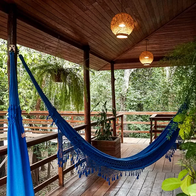 Blaue Hängematte auf der Holzveranda eines Superior-Chalets der Manati Lodge im Amazonas-Regenwald, Brasilien.