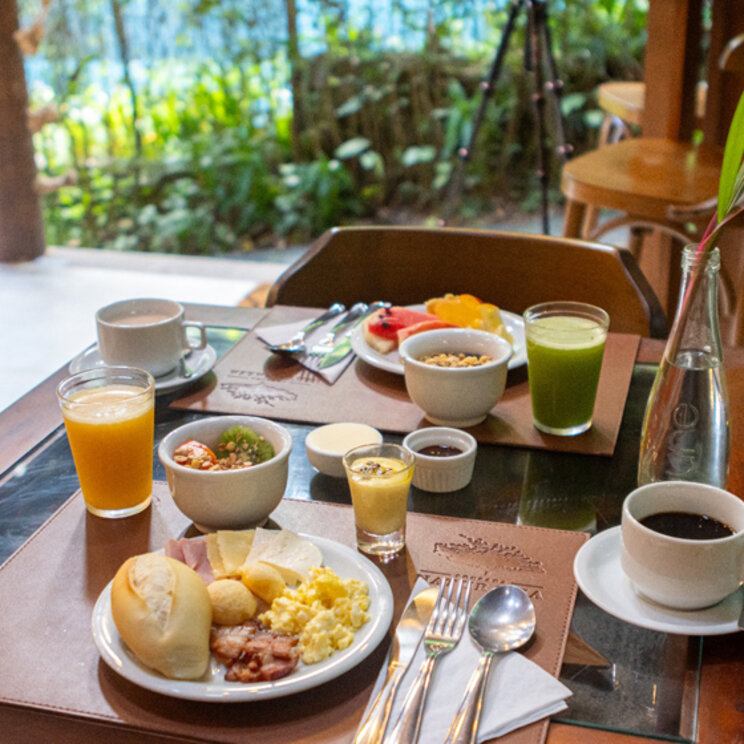 Gedeckter Frühstückstisch mit Kaffee, Säften, Obst und Brötchen in der Pousada Naturalia, Ilha Grande.