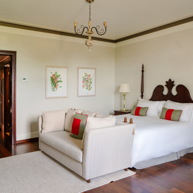 Junior Suite im Hotel das Cataratas mit hellem Sofa, klassischem Doppelbett und Holzboden in Foz do Iguacu, Brasilien.