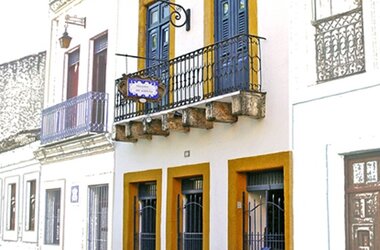 Historische Fassade der Pousada do Amparo mit Balkon an einer Kopfsteinpflasterstraße in Olinda, Brasilien.