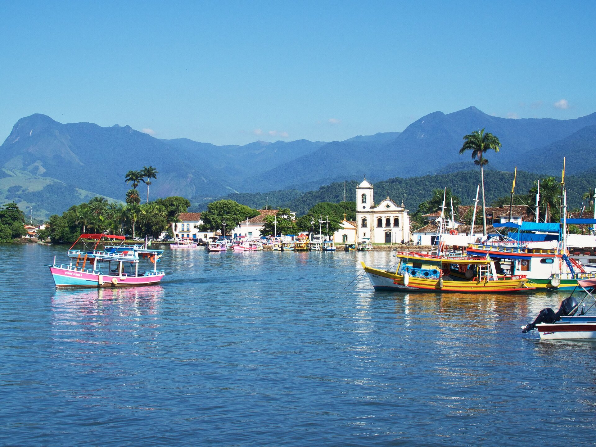 Blick auf den Hafen von Paraty, Brasilien, mit bunten Booten im Wasser.