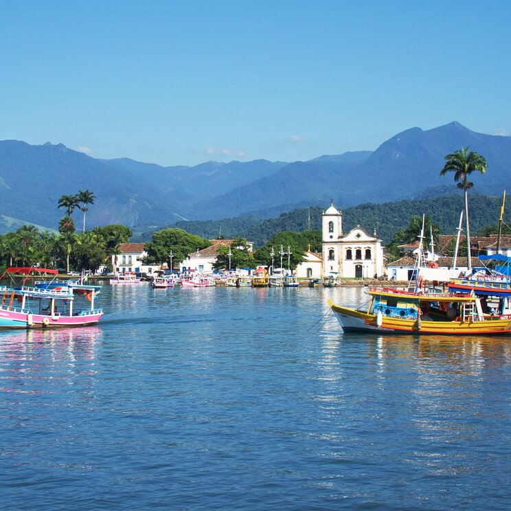 Blick auf den Hafen von Paraty, Brasilien, mit bunten Booten im Wasser.