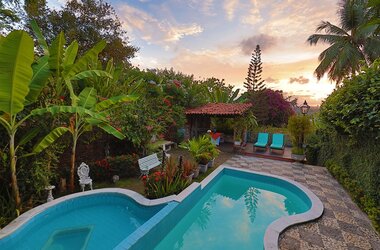 Außenpool im tropischen Garten der Pousada do Amparo bei Sonnenuntergang in Olinda, Brasilien.