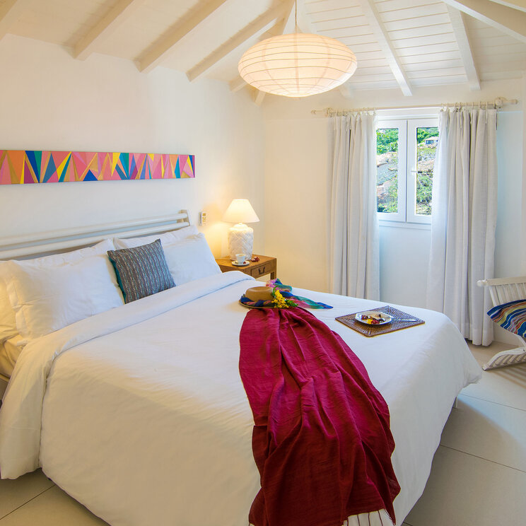 Zimmer in der Pousada La Chimére in Búzios mit einem modernen, hellen Design, einem Doppelbett und einer gemütlichen Atmosphäre.