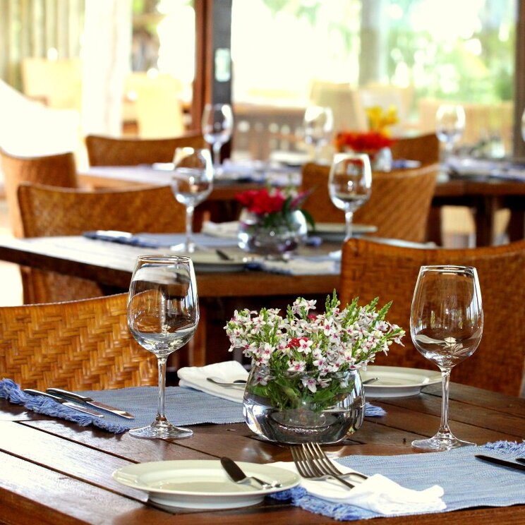 Elegantes Restaurant in der Pousada Maravilha in Fernando de Noronha, Brasilien, mit liebevoll gedeckten Tischen und Blumendekoration.