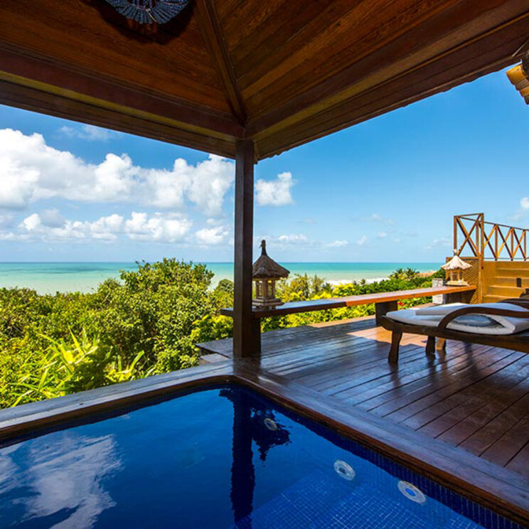 Überdachter Balkon mit privatem Pool, Sonnenliegen und Panoramablick auf den Ozean.