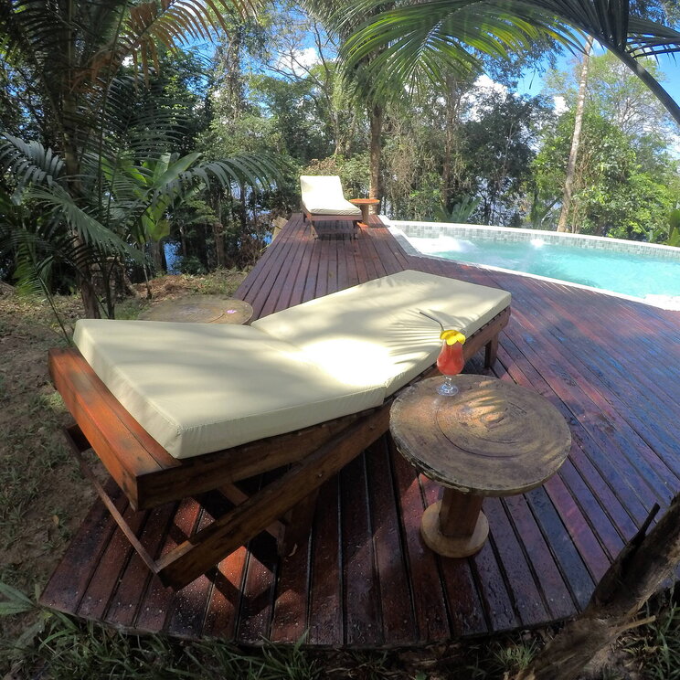 Poolbereich der Amazon Premium Lodge im Amazonas, Brasilien, mit Liegestühlen und einem erfrischenden Getränk.