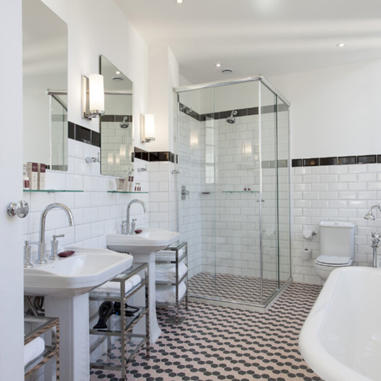 Modernes Badezimmer mit freistehender Badewanne, Glasdusche und zwei Waschbecken im Fera Palace Salvador.