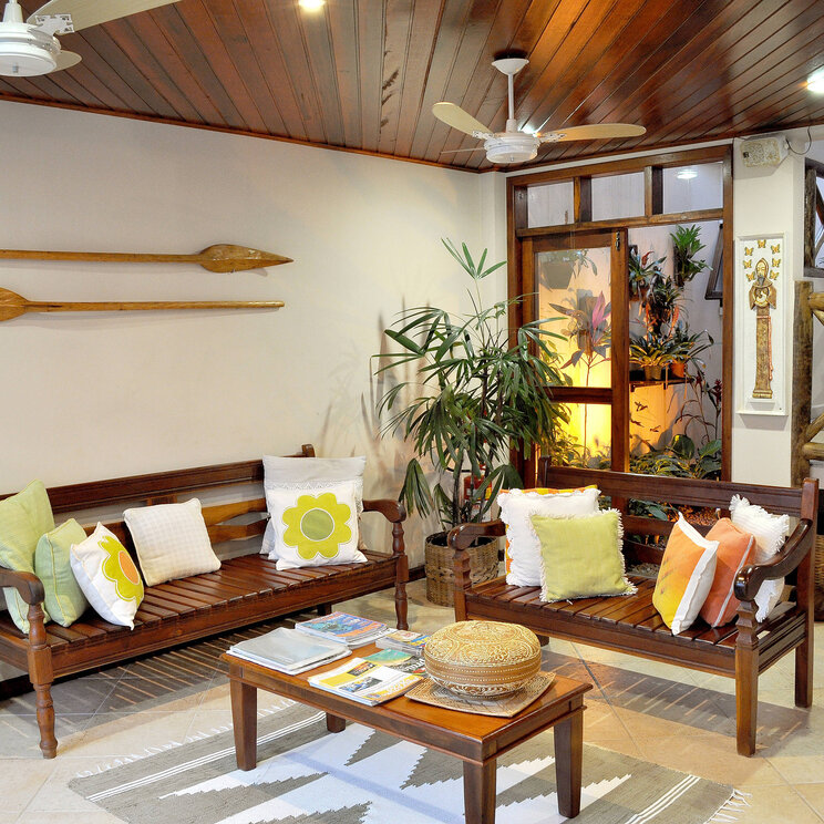 Gemütlicher Lounge-Bereich in der Pousada Caiçara auf der Ilha Grande, Brasilien, mit Holzmöbeln und maritimen Dekorationen.