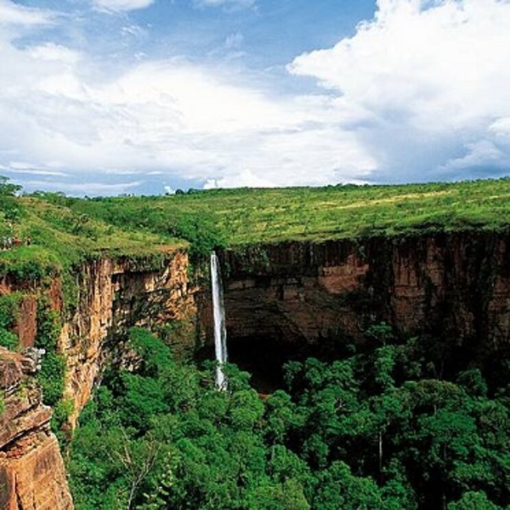 Hoher Wasserfall inmitten üppiger Vegetation in der Chapada dos Guimarães, Brasilien, während einer Mietwagentour.