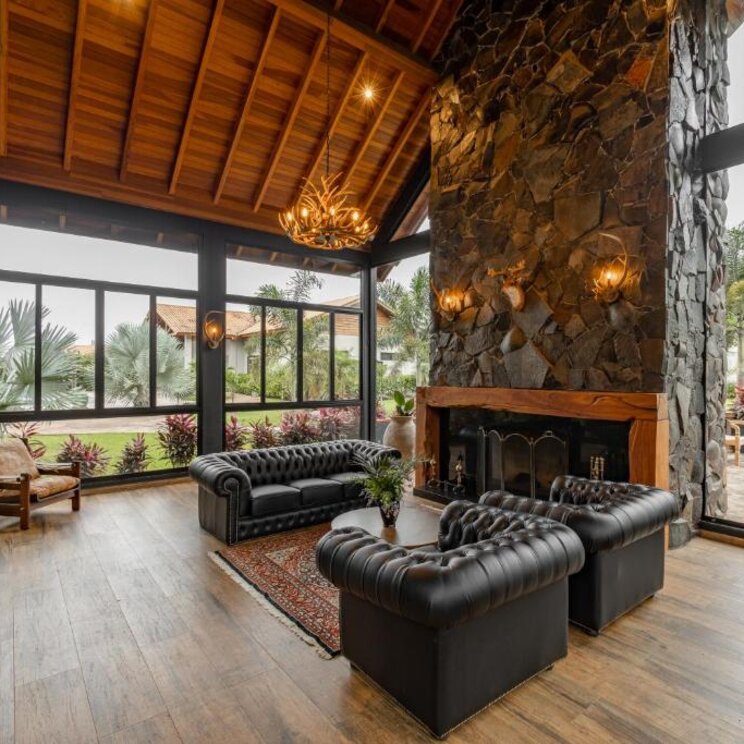 Stylischer Sitzbereich mit gemütlichen Ledersofas und offener Steinwand im Las Hotel Boutique in Foz do Iguaçu, Brasilien.